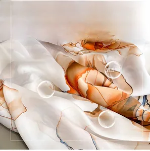 Detailed texture of lightweight faux silk shawl with orange floral pattern and soft folds