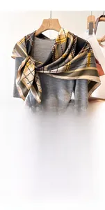 Detail of 90cm twill silk scarf with brown geometric check pattern draped over a sweater