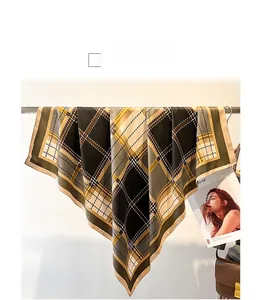 Detail of vintage plaid silk scarf in brown and yellow draped over a metal rod