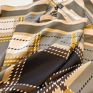 Detail of silk-feeling twill square scarf with elegant geometric color blocking and texture