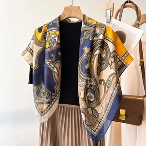 Détail d'un grand foulard carré effet soie avec motif cachemire et bordure bleue