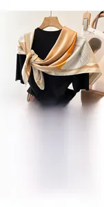 Detail of a 90cm geometric silk-like scarf styled with a black top and pleated skirt