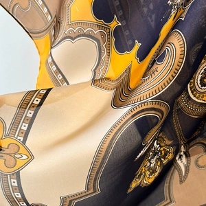 Détails macro du motif baroque géométrique bleu marine et doré sur foulard en soie