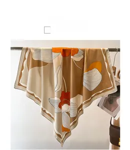 Detail of elegant large square silk scarf featuring abstract floral patterns in caramel tones
