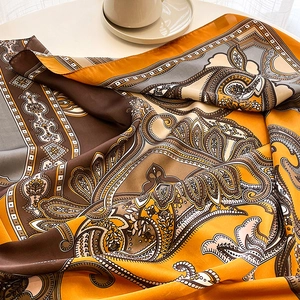 Détail d'un foulard en soie avec motif paisley jaune et bords ourlés lisses