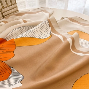 Detailed view of the smooth silk-like texture and earthy abstract floral pattern scarf