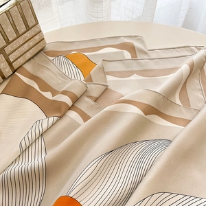 Close-up of lightweight silk square scarf with abstract artistic patterns in earth tones