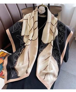 Detail view of large floral print silk scarf with camellia pattern on a black background