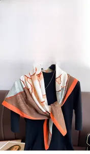 Detailed close-up of vintage floral twill silk scarf in orange and coffee tones