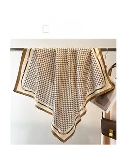 Detailed view of large twill silk scarf with houndstooth and golden chain pattern
