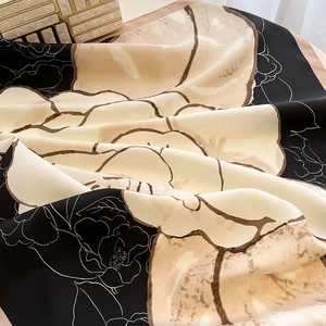 Detail of silk-texture floral scarf showing elegant camellia pattern and glossy fabric