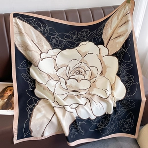Detailed close-up of a large white camellia floral print on a black silk square scarf