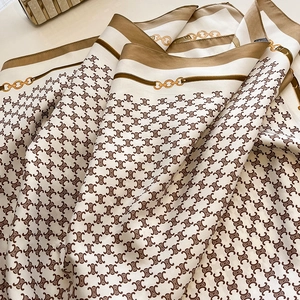 Detail of luxury silk scarf with beige and gold belt pattern and elegant draping