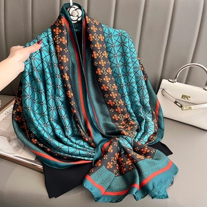 Elegant geometric floral silk scarf with blue and orange patterns on a luxury background