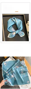 Dettaglio macro del foulard di seta blu con stampa floreale retrò e bordi fini
