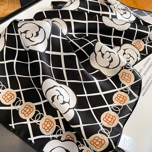 Detailed view of camellia floral pattern on a 100% mulberry silk checkered square scarf