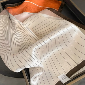 Macro detail of 53x53cm geometric pure silk scarf with elegant satin finish in gift box