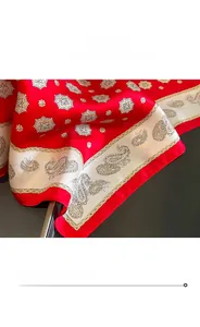 Gros plan du foulard en soie rouge avec motif cachemire et coutures de bordure fines