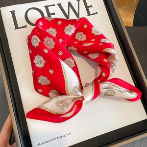 Carré de soie élégant avec motif paisley rouge posé sur un magazine de mode