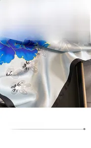 Detail of premium silk scarf featuring blue floral prints and precise rolled hem edges