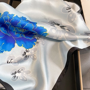 Elegant silk scarf featuring blue floral prints with premium satin finish and black borders