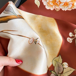 Macro shot of silk scarf showing detailed floral print and luxurious satin texture