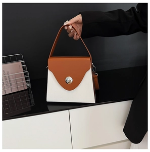 Détail du sac boîte contrasté avec rabat orange et corps blanc à texture fine