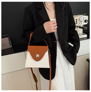 Sac boîte bicolore à texture ondulée et boucle argentée porté par un mannequin