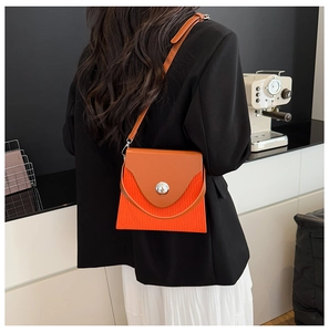 Vue détaillée du sac à bandoulière plissé orange avec une boucle ronde en argent