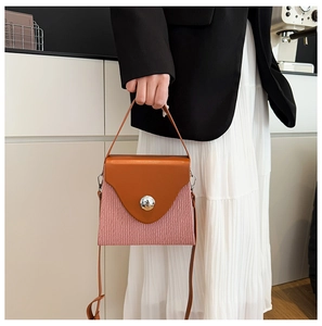 Détail du sac boîte tendance avec texture plissée rose et rabat en cuir marron chic