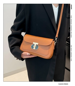 Détail du sac bandoulière en cuir marron avec boucle en T dorée et surpiqûres