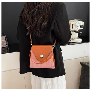 Détail du sac à bandoulière rose et marron avec fermoir rond argenté et fine lanière