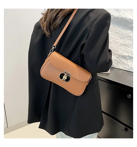 Vue détaillée du sac bandoulière en cuir marron avec fermoir métallique en T