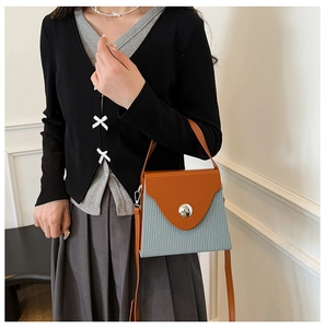 Détail du sac boîte tendance avec rabat en cuir marron et corps en tissu bleu clair