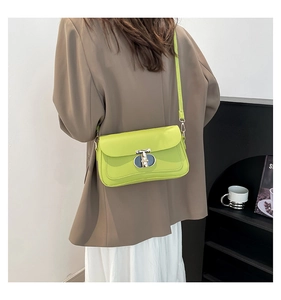 Détail du sac à bandoulière vert fluo avec fermoir métallique porté par un mannequin