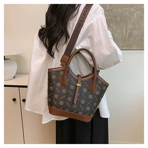 Close-up of vintage brown patterned handbag featuring wide fabric shoulder strap and texture