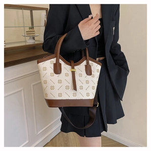 Detail of printed tote bag featuring clover patterns and a stylish wide shoulder strap
