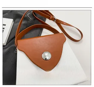 Détail d'un sac color-block avec une grande boucle ronde argentée et un tissu tissé