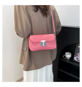 Détail du sac à bandoulière rose avec fermoir en T et bords de rabat surpiqués