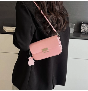 Detailed close-up of pink leather crossbody bag with a gold rectangular metal buckle