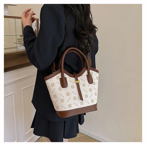 Detailed back view of a beige tote bag with clover print and dark brown leather trim