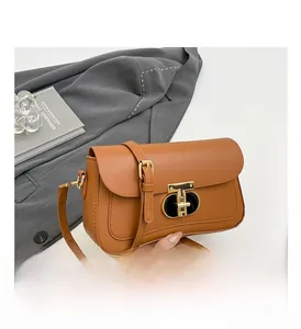 Détail d'un sac carré rétro marron avec fermoir doré en T et bandoulière réglable