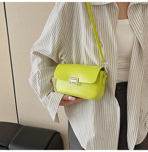 Detailed close-up of a neon green leather shoulder bag with a silver metallic buckle