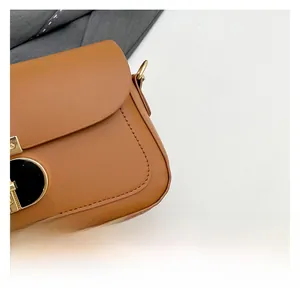 Détail du sac bandoulière en cuir caramel avec fermoir doré et coutures de précision
