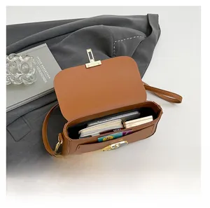 Vue intérieure d'un sac bandoulière marron en similicuir montrant les compartiments utiles