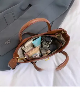 Top view of brown leather handbag interior showing large capacity and multi-layer storage