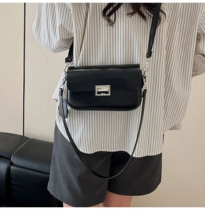 Detail of black rectangular leather crossbody bag with silver geometric metal buckle lock