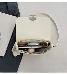 Top view of cream white shoulder bag showing organized interior with zipper compartment