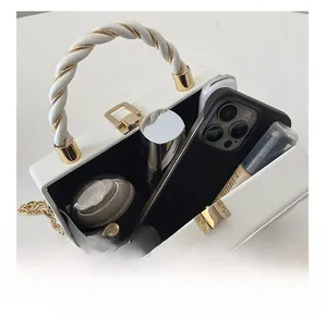 Detailed interior of a white wave patterned handbag with gold hardware and spacious storage