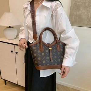 Retro brown monogram tote bag with wide fabric strap shown in a home lifestyle setting